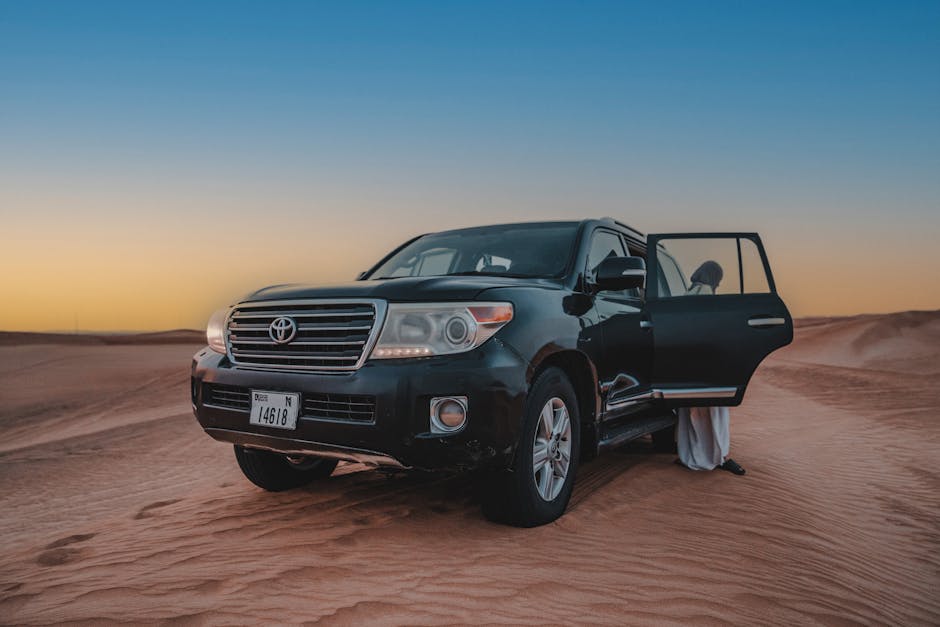 Black SUV off-roading in desert at sunset, person entering vehicle.